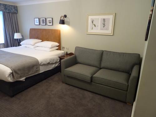 a hotel room with a bed and a couch at The Belmore in Sale