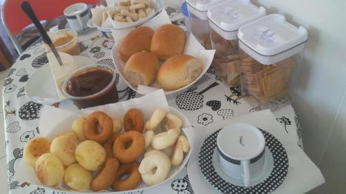 Ein Tisch, auf dem drei Teller mit Donuts und Dips gedeckt sind. in der Unterkunft Pousada toca da coruja in Contagem