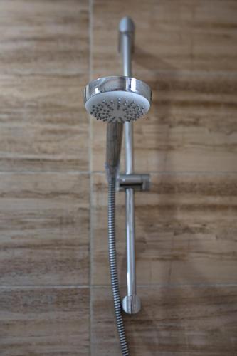 a shower with a shower head in a bathroom at Airport House in Otopeni