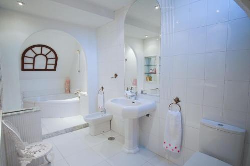 a white bathroom with a sink and a toilet at Chalet con piscina y 2000 m de jardín in Vigo