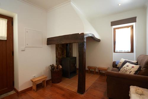 a living room with a couch and a fireplace at Casa da Eira - Água Formosa _ Vila de Rei in Vila de Rei