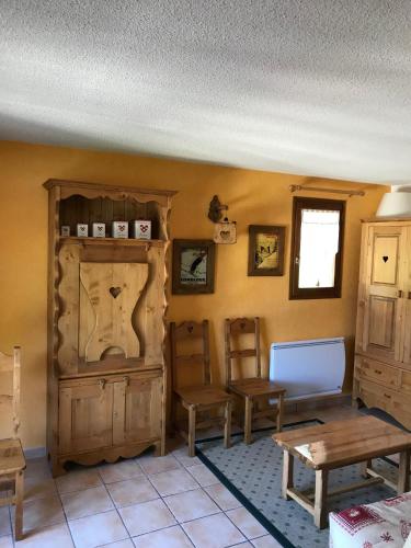 - un salon doté d'un mobilier en bois et d'une table dans l'établissement Le Croisse Baulet, à La Giettaz