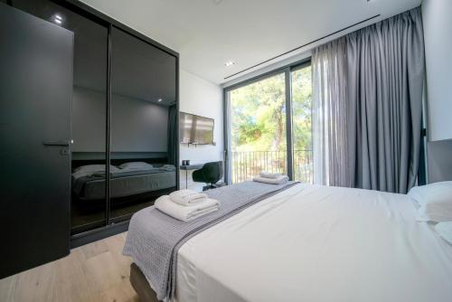 a bedroom with a large white bed and a window at The Duke Boutique Suites in Athens