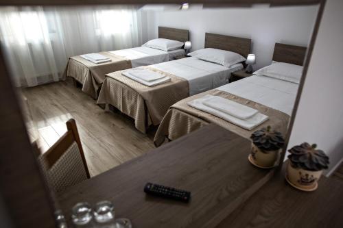 a view of a room with two beds and a mirror at Airport House in Otopeni