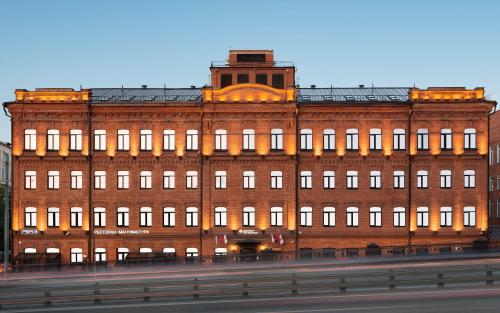 a large red brick building with a clock tower at AZIMUT Hotel Tulskaya Moscow in Moscow