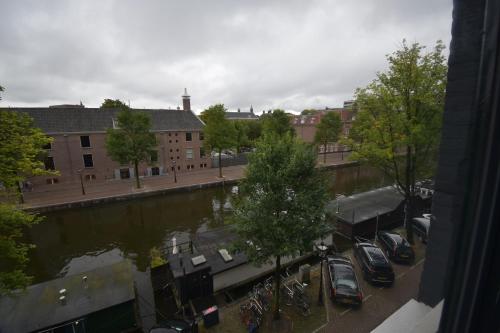 a view of a city with cars parked next to a river at Hotel Hermitage Amsterdam in Amsterdam