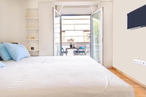 une chambre avec un grand lit blanc et un balcon dans l'établissement Photographers House, à Athènes