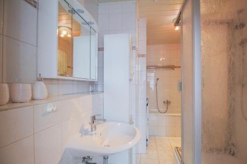 a white bathroom with a sink and a shower at Ferienwohnung Zum Lilienstein in Bad Schandau