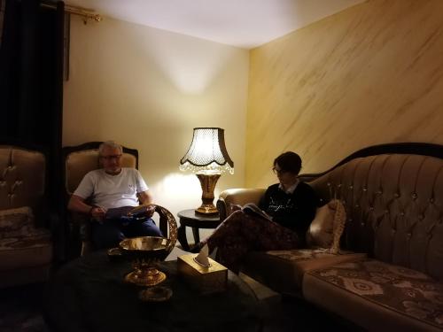 a man and a woman sitting in a living room at Mhna guest house in Ajloun