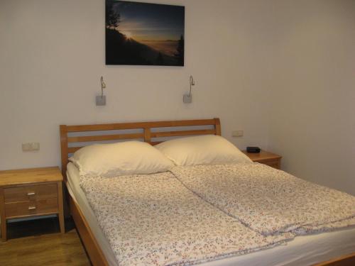 - une chambre avec un lit et une photo sur le mur dans l'établissement Ferienwohnung Brandtner Leogang, à Leogang