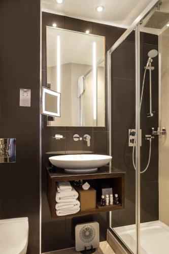 a bathroom with a sink and a shower at Montcalm Piccadilly Townhouse, London West End in London