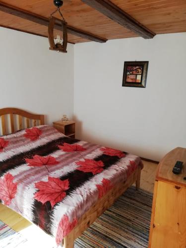 a bedroom with a bed with a quilt on it at Rustic Rooms in Râşnov