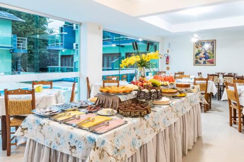 una mesa larga con comida en un restaurante en Hotel Cores do Mar, en Bombinhas
