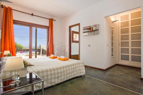 a bedroom with a bed and a large window at Villa Corito in Playa Blanca
