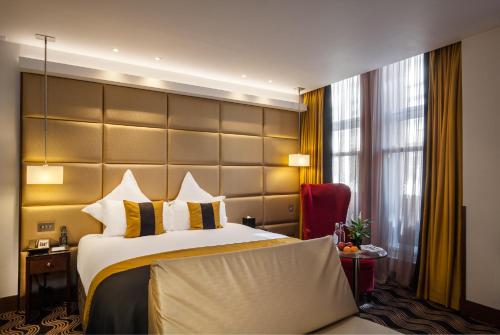 a bedroom with a large bed and a large window at The Piccadilly London West End in London