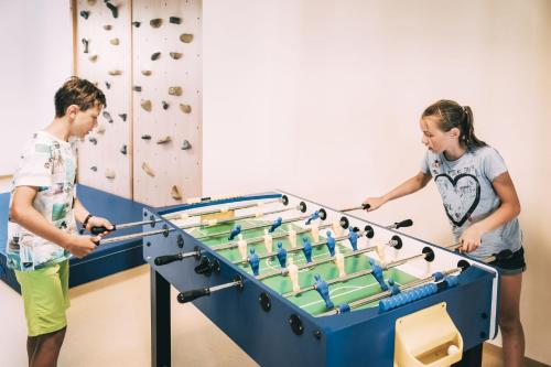 a man and a woman playing with a large pool table at Kinderhotel Stegerhof in Donnersbachwald