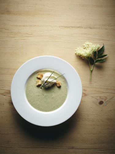 a bowl of soup and a flower on a table at Kinderhotel Stegerhof in Donnersbachwald