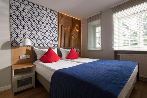 um quarto com uma cama grande e almofadas vermelhas em Anchor House Sopot em Sopot