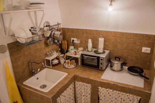 a kitchen counter with a microwave and a sink at Casa Nori in Polignano a Mare