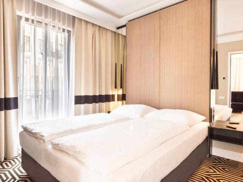 sypialnia z dużym białym łóżkiem i oknem w obiekcie VacationClub – Baltic Park Fort Apartament E.202 w Świnoujściu