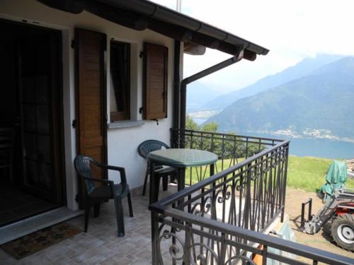 a balcony of a house with a table and chairs at Agriturismo Piccolo paradiso in Pianello Del Lario