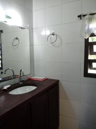 a bathroom with a sink and a mirror at Casa na Praia do Rosa in Praia do Rosa