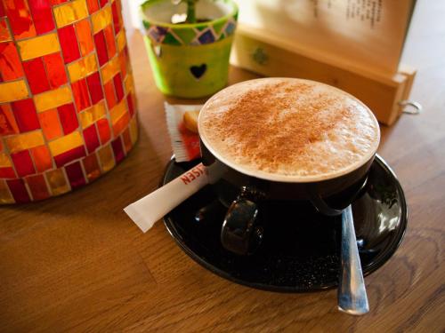 a cup of coffee sitting on top of a table at Nangijala Hostel in Disentis