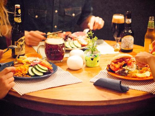 a wooden table with plates of food on it at Nangijala Hostel in Disentis