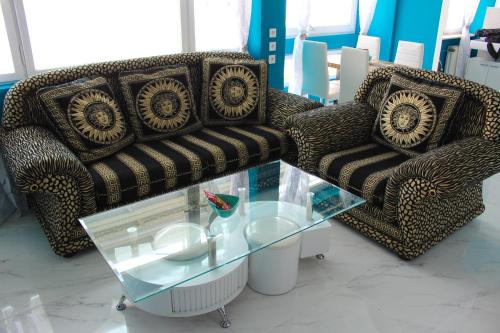 a living room with two chairs and a glass table at Skyhostel Friedrichshafen in Friedrichshafen
