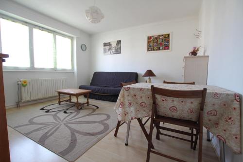 uma sala de estar com uma mesa e cadeiras e um sofá em Colmar Nature - Quiet Apartment MARAICHERS em Colmar