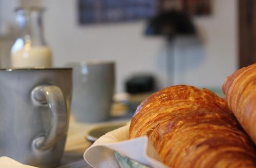 Een brood ligt op tafel met een kopje. bij Le Chemin du Village in Croth