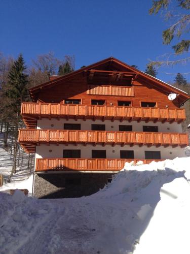 a large wooden building with a bridge in the snow at Apartmánový dom Poludnica I., Chopok Juh, Jasná in Tale