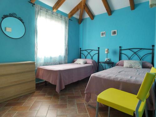 two beds in a room with blue walls at Arriba y Abajo Cadiz in Zahora