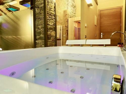 a large tub in a bathroom with a sink at Villa Ottocento in Campertogno