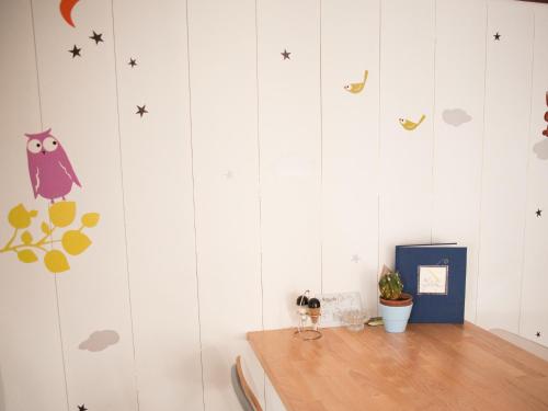a room with white walls with stars and an owl decals at Nangijala Hostel in Disentis