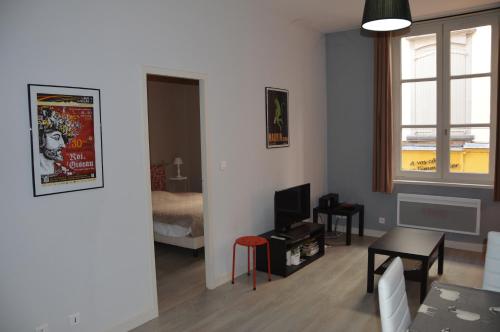 una sala de estar con una habitación con cama y TV en Logis du Cagaïre, en Le Puy en Velay