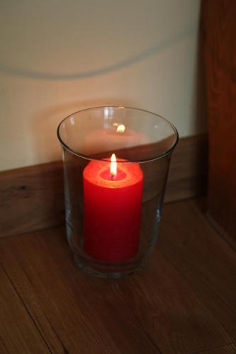 a red candle in a glass jar on a table at KrokusChata pod Sokolicą in Krościenko