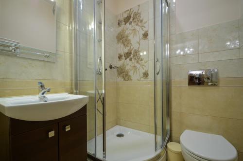 uma casa de banho com um chuveiro, um lavatório e um WC. em KrokusChata pod Sokolicą em Krościenko