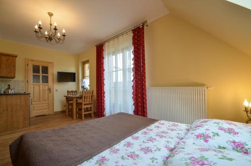a bedroom with a bed and a kitchen with a table at KrokusChata pod Sokolicą in Krościenko