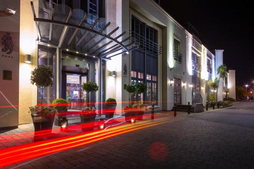 a building with red lights on a street at night at Talbot Hotel Stillorgan in Stillorgan