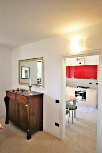 a room with a table and a kitchen with red cabinets at LA VALLETTA MAISON in Ponteranica