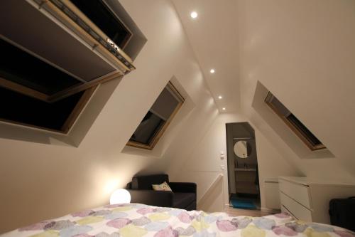 um quarto com uma cama e uma cadeira em Colmar City Center - Appartement BELLE-VUE 4 étoiles em Colmar