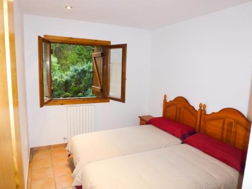 フォルミガルにあるApartamentos Formigal - admite mascotasのベッドルーム1室(ベッド2台、窓付)