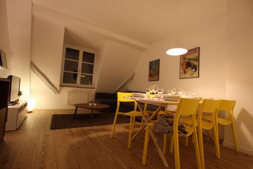 comedor con mesa y sillas amarillas en Colmar City Center - Cosy Appartement BED' N' BREDALA Max, en Colmar