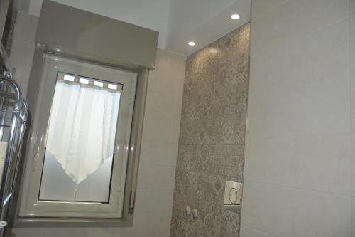 a window in a bathroom with a shower with a curtain at ART B&B in Caltanissetta