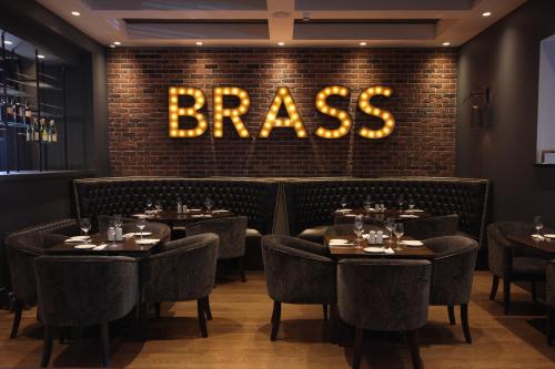 a restaurant with tables and a sign that reads brass at Talbot Hotel Stillorgan in Stillorgan