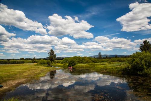 a couple of people in a boat on a river at Bend-Sunriver Camping Resort 24 ft. Yurt 9 in Sunriver