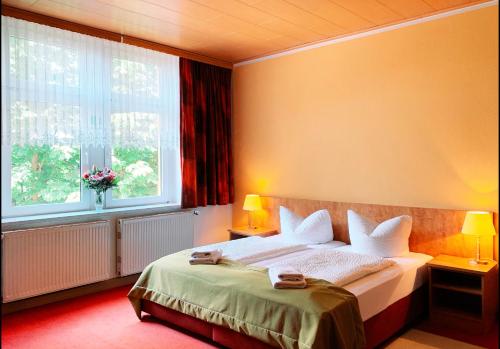 a bedroom with a large bed with two windows at Traditionsgasthaus Goldener Löwe Riesa Restaurant & Pension in Riesa