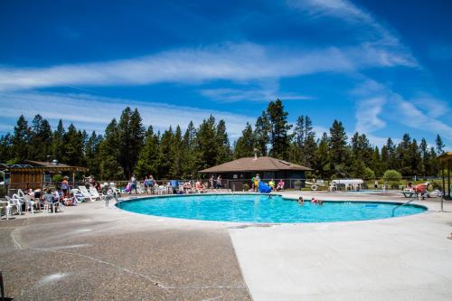 ein großer Pool mit Leuten, die um ihn herum sitzen in der Unterkunft Bend-Sunriver Camping Resort 24 ft. Yurt 16 in Sunriver