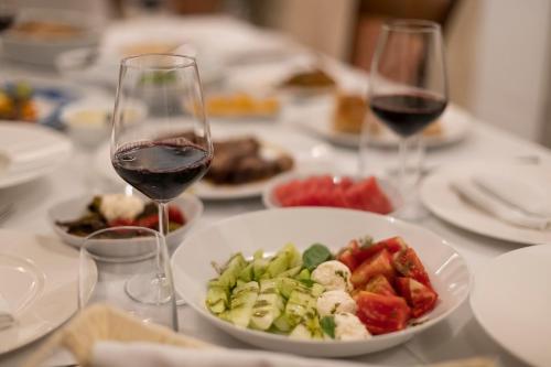a table with two glasses of wine and a plate of food at Agroturizem Gjepali in Shijak